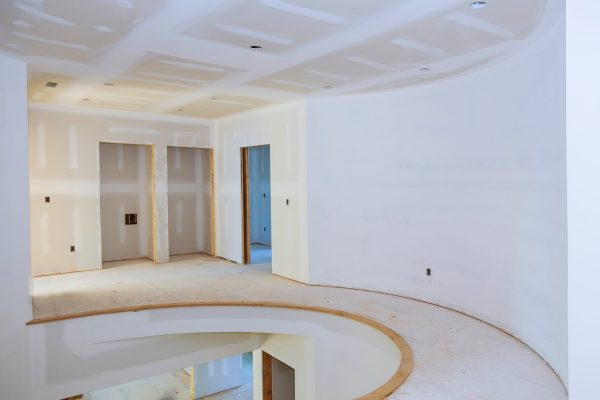 Walls of Interior construction of housing project with drywall installed and patched without painting applied